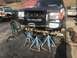 1989 Ford Bronco - Front view of a black Ford Bronco undergoing repairs, with another truck in the background.