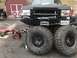 1989 Ford Bronco - A heavily modified black truck with oversized tires and a winch is parked outside a red shed. The vehicle has a Maryland license plate.
