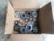 1989 Ford Bronco - A collection of vehicle drivetrain parts, including lockout hubs and gears, are laid out in a cardboard box.