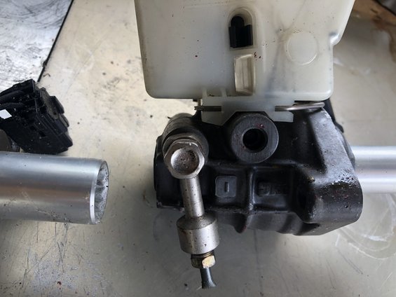 Close-up of a brake master cylinder reservoir and body with metal tubing