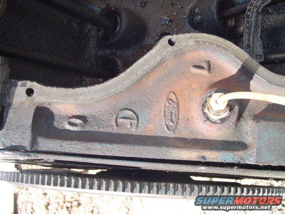 Close-up of a Ford engine block with a "Ford" oval logo and some cast numbers