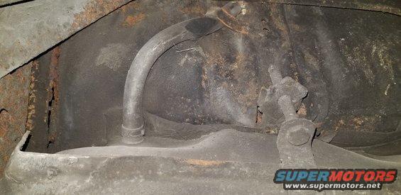 Underside of a vehicle showing fuel tank, fuel line, and rust.