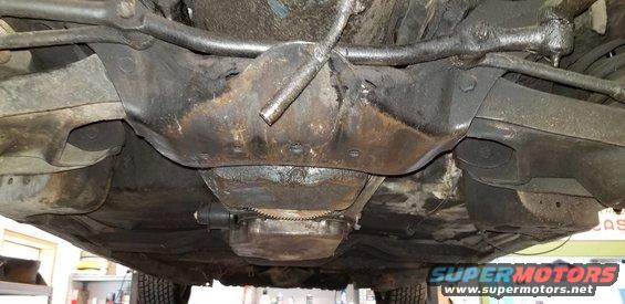 Underside view of a classic car showing front suspension and engine.