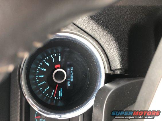 Car dashboard with a circular speedometer and odometer showing 46666.9 miles