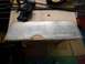 1977 Ford Ranchero - A metal template with marked drill points is clamped to a wooden surface, suggesting a custom part fabrication.