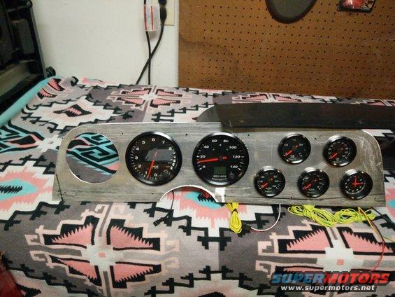 Dashboard with multiple gauges and wiring, on a patterned blanket