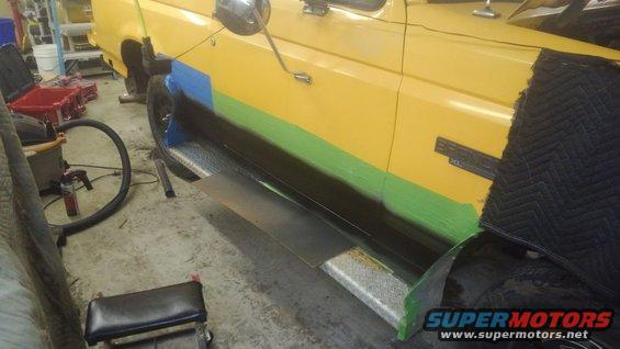 Yellow 1996 Ford Bronco side with green and black tape on lower body panels