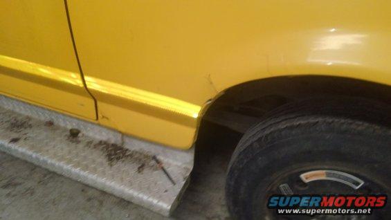 Yellow vehicle side panel with a step and rear wheel visible. Supermotors.net logo in corner