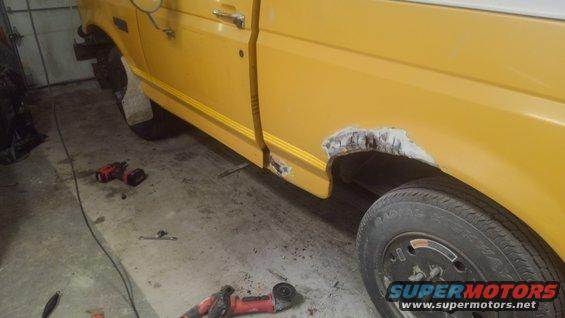 Yellow truck side view showing rust around wheel well and tools on floor