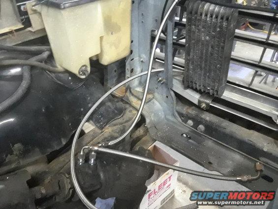 Engine bay with fluid reservoir, oil cooler, and metal lines