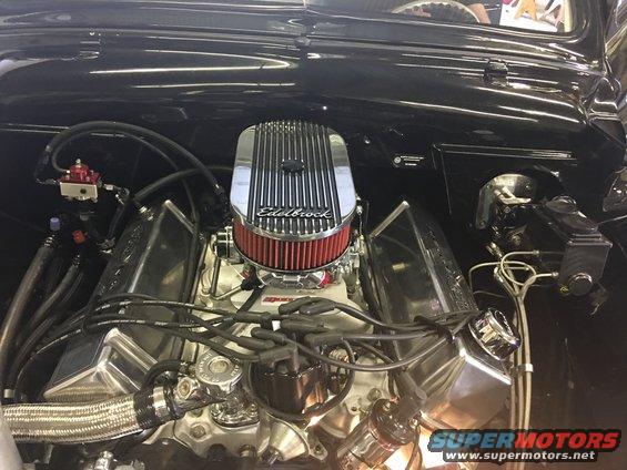 Engine bay showing a V8 engine with chrome valve covers and an Edelbrock air cleaner. Fuel lines and wiring are visible
