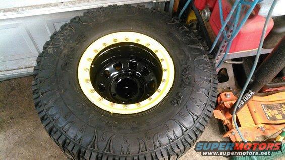 Off-road tire with yellow beadlock ring on a black steel wheel