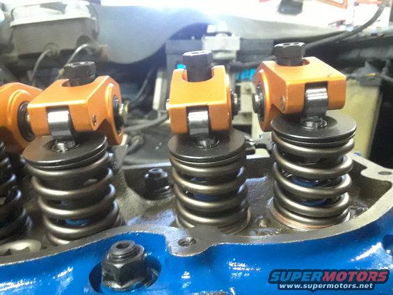 Close-up of orange roller rocker arms and valve springs on an engine