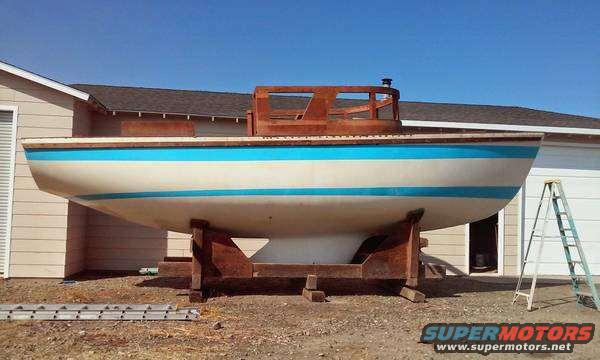 Boat on a stand in front of a building, with a ladder nearby
