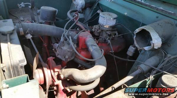 Engine bay with red engine block, air filter, and hoses