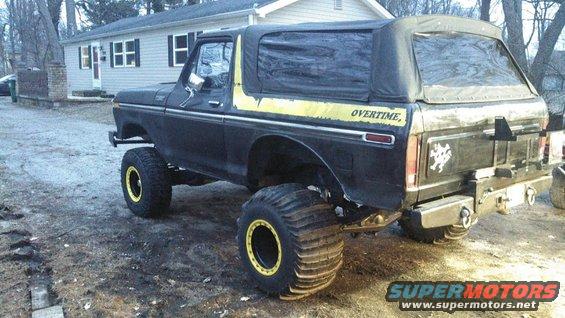 Black 1978 Ford Bronco with yellow stripe and "OVERTIME" text, lifted with large paddle tires