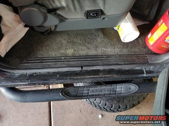 Vehicle interior showing a step bar with 'WILDCAT FLASH' text, tire, and seat
