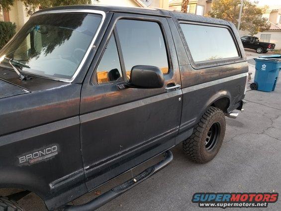 1993 Ford Bronco side view, dark paint, aftermarket side steps and wheels