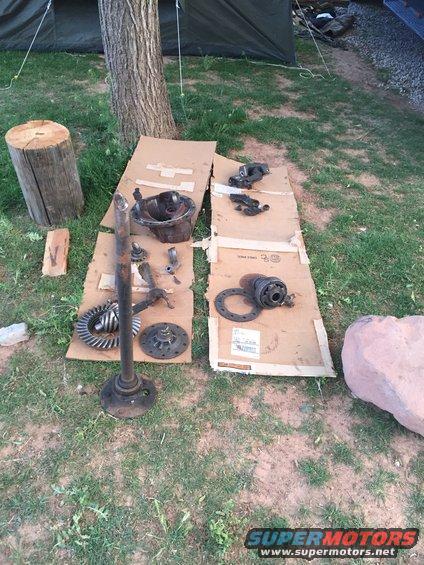 differential housing, gears, and axle shaft laid out on cardboard