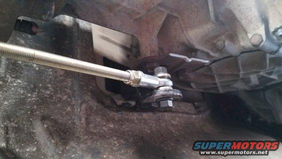 close-up of transmission linkage with metal rod and bolts