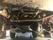 1984 Ford Bronco - Undercarriage view of a vehicle's suspension and drivetrain components, supported by jack stands.
