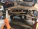 1984 Ford Bronco - Underbody view of a vehicle's suspension and drivetrain components, raised on jack stands for maintenance.