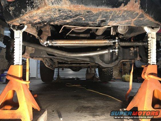 Undercarriage view of vehicle on jack stands, showing steering linkage