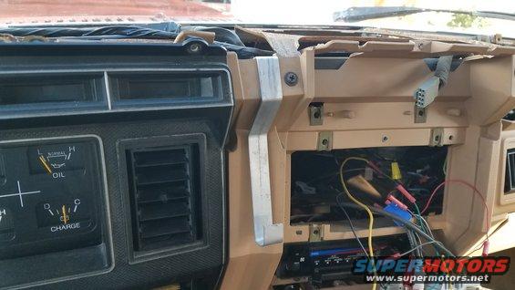 Tan dashboard with exposed wires and an oil gauge