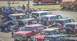 1979 Ford Bronco - A collection of Ford Bronco SUVs are gathered in a parking lot on a sunny day.