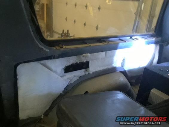 Interior view of vehicle with white insulation and gray seats
