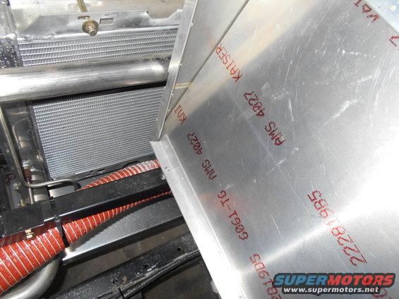 Aluminum panel with red markings 'AMS 4027 KAISER' and 'G061-T6' next to a vehicle radiator