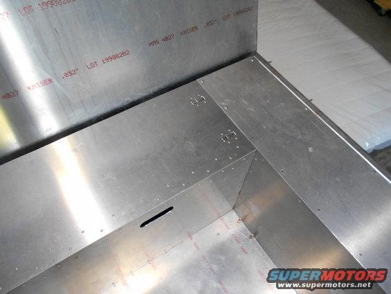 Aluminum interior of a vehicle with visible rivets and red stamped text