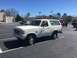 1979 Ford Bronco - White Ford Bronco parked in a lot with other vehicles and buildings visible.