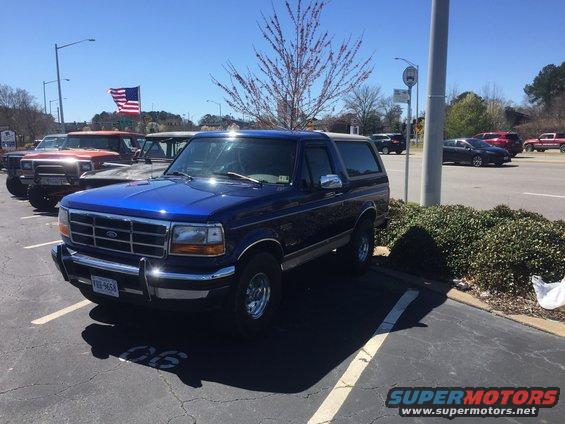 Blue Ford Bronco parked in a lot, front quarter view