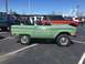 1979 Ford Bronco - Side view of a green 1979 Ford Bronco. Other vehicles are parked nearby.