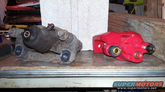 Old rusty brake caliper next to a new red brake caliper