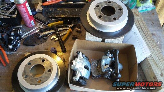 Brake rotors and calipers with tools on a workbench