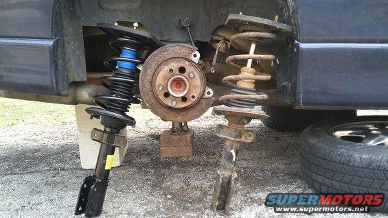 Car's rear suspension with a new shock absorber and a rusty old one removed