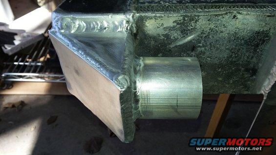 Custom aluminum intercooler piping with visible welds and a metal tube outlet