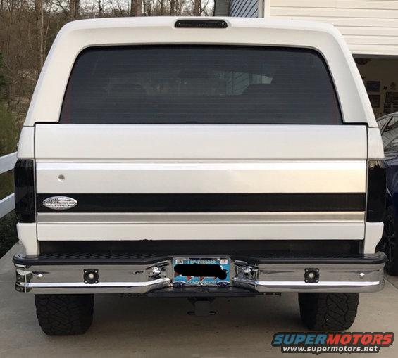 Rear view of a white 1995 Ford Bronco with tinted windows and a black stripe