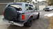 1995 Ford Bronco - This 1995 Ford Bronco is seen from the rear, a spare tire mounted on the tailgate and a second white pickup truck in the background.