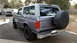 1995 Ford Bronco - Rear view of a gray 1995 Ford Bronco, showing its spare tire carrier and aftermarket wheels.