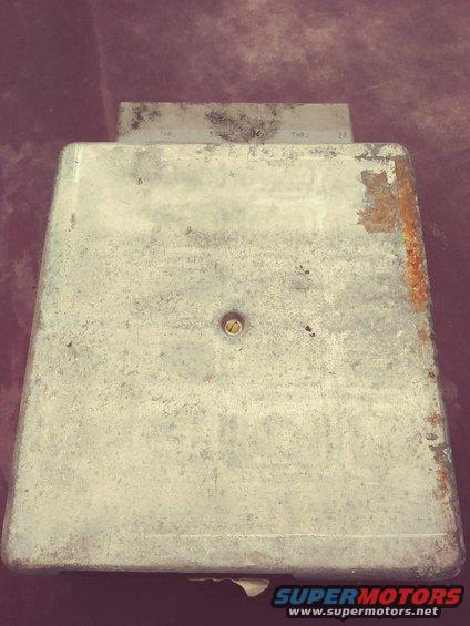 Metal automotive computer module with visible text and rust