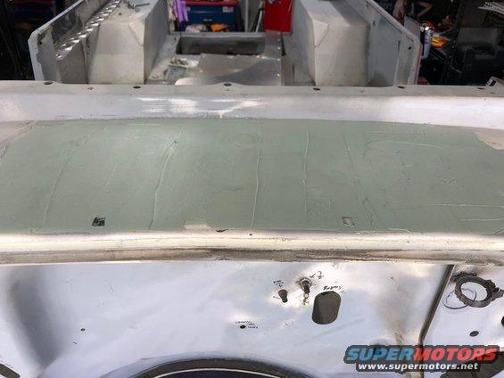 Jeep tub with body filler applied to the cowl area, showing metalwork and some holes