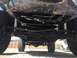 1984 Ford Bronco - The underside of a vehicle is captured from a low angle, revealing its mechanical components and tires.