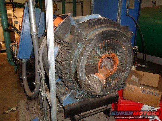 Industrial electric motor with rusted shaft and blue housing, seen from the front