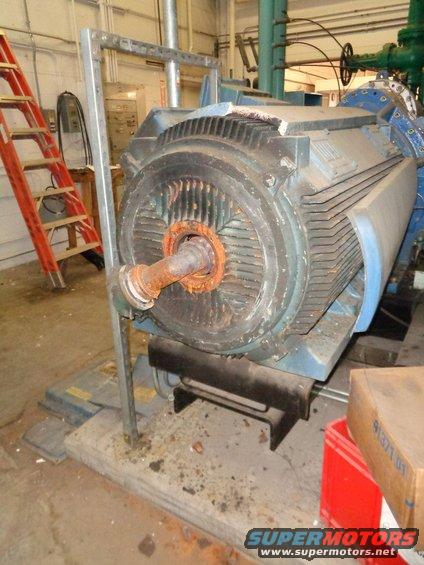 Large industrial electric motor with rusted shaft and fins
