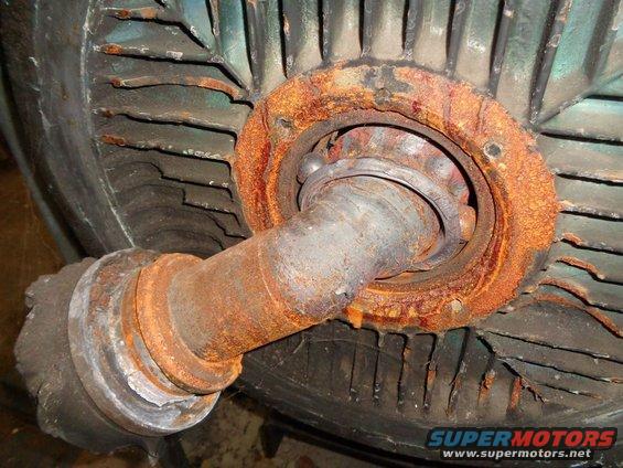 rusted bearing and shaft assembly with fan blades in background