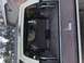 1995 Ford Bronco - The interior of a white 1995 Ford Bronco shows a roll cage and a folded rear seat.