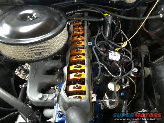 Engine bay with air cleaner, valve covers, and wiring visible
